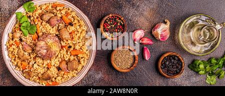 Pilav mit Fleisch, Gemüse und Gewürzen, Ansicht von oben. Stockfoto