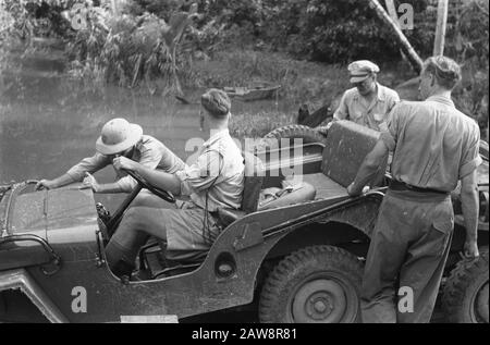 Besuch der US-Konsularmission in Palembang [Mitglieder, die der US-Konsularmission mit dem Vorstoß eines Jeeps helfen, der gestrandet ist, Leiter des vorderen Helm der US-Mission Colonel Collin S. Myers. Rechter Oberstleutnant W. Allison IND Datum: 17. Oktober 1947 Ort: Indonesien, Niederländische Ostindien, Palembang, Sumatra Stockfoto