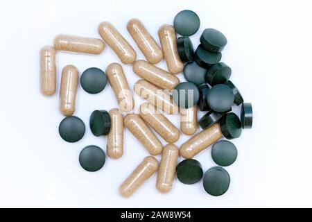 Grüne runde Pillen und Kapseln Draufsicht. Nahrungsergänzungsmittel in Tabletten. Aloe- und Chlorella-Kapseln in Tabletten auf weißem Hintergrund. Die Verwendung von Algen Stockfoto