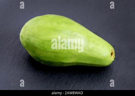 Geschältes Avocado auf schwarzem Hintergrund. Ganz grüner Avocado auf der Tischansicht. Reifer Avocado zum Frühstück. Stockfoto