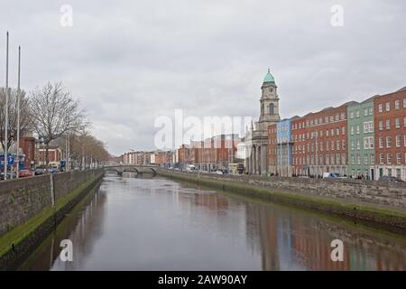 Die Kirche von Saint Paul in der griechischen Wiederauflebungsarchitektur, entworfen von Patrick Byrne, und die farbenfrohen Apartmentgebäude entlang des Flusses Liffey, Dublin Stockfoto