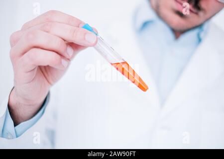 Ein Arzt, der in einem Labor mit Reagenzgläsern medizinisch untersucht Stockfoto