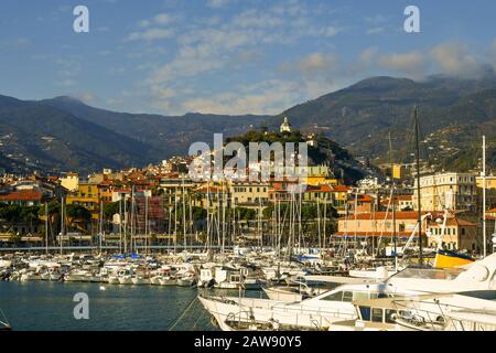 Schöner Blick auf den Hafen mit Segelyachten und Segelbooten und die Lady of the Coast Sanctuary auf einem Hügel an einem sonnigen Tag, Sanremo, Ligurien, Italien Stockfoto