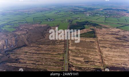 Luftaufnahme der Landstraße durch die Torfmoorlandschaft im ländlichen Irland Stockfoto