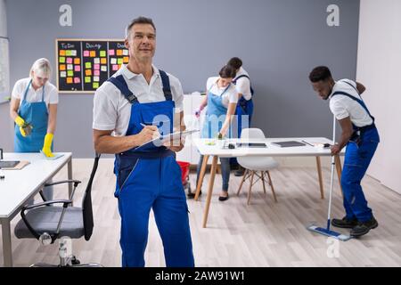 Hausmeister mit seinem Team Reinigung modernes Büro Stockfoto