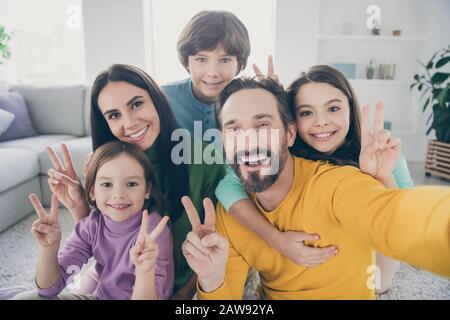 Selbstporträt von netten attraktiven großen fröhlichen fröhlichen Familien Kinder vor Teenagern Mama Papa mit Spaß beim zeigen von V-Zeichen in gemütlichem Hellweiß Stockfoto