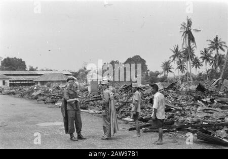 Bericht Deli Toea niederländischer Soldat steht unter den Ruinen. Neben ihm ein japanischer Gefangener mit kap, flankiert von zwei Männern in Zivildatum (?): Juli 1947 Ort: Indonesien Niederländisches Ostindien Stockfoto