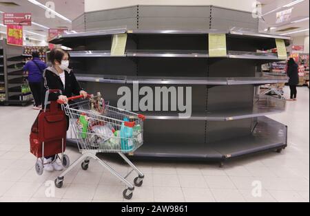 Hongkong, CHINA. Februar 2020. Eine Frau geht an völlig leeren Regalen für die Vorräte an Gewebepapieren vorbei. Alle Papierprodukte, insbesondere toilettenpapier, sind in den Supermärkten in einem ernsten Versorgungsengpass, da es in der Stadt zu einer Panikattacken kommt. Kredit: Liau Chung-ren/ZUMA Wire/Alamy Live News Stockfoto