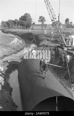 Artwork d Date: 1965 Schlüsselwörter: Arbeiter, Baustellen, Taucher, Taucher und Hecke, Graben und Befüllen von Schützengräben, Kränen, Legeabflüsse, Normalisierung von Bächen Personenname Land Wetter Bridge Institution Name: Wasser Schipbeek Stockfoto