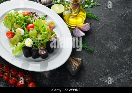 Salat mit Gemüse, Blutwurst und Pilzen auf einem Teller. Draufsicht. Freier Speicherplatz für Ihren Text. Rustikaler Stil. Stockfoto