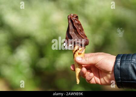Mann mit Eiskegel. Schokoladeneis Stockfoto