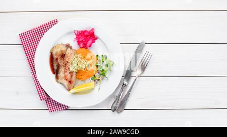 Gebackenes Fischfilet mit Kartoffelpüree. In der Platte. Draufsicht. Freier Speicherplatz für Ihren Text. Rustikaler Stil. Stockfoto