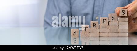 Nahaufnahme der Hand letzte Alphabet der Person des Wortes Stress auf hölzernen Block Stockfoto