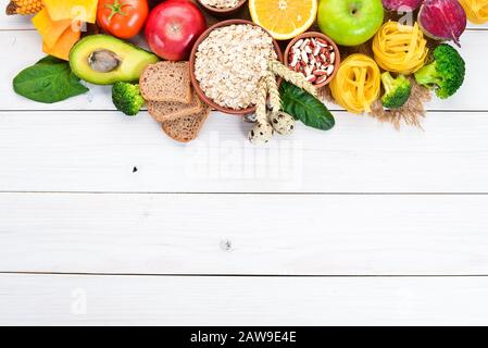 Konzept der gesunden Ernährung: Brot, Pasta, Avocado, Mehl, Kürbis, Brokkoli, Bohnen, Spinat. Gemüse und Obst. Draufsicht. Freier Speicherplatz. Stockfoto