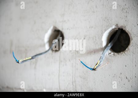 Elektrische Arbeiten mit rauer Oberfläche, Elektriker verbindet und montiert Kupferdrähte für die Steckdose in der Wohnung. Stockfoto