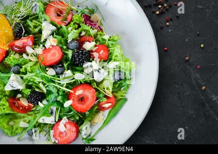 Salat. Salat aus Arugula, Blaukäse, Erdbeeren und Blaubeeren. Draufsicht. Stockfoto