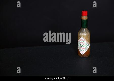 McIlhenny Co. Tabasco Marke Pepper Sauce Flasche isoliert auf schwarzem Hintergrund mit Kopierraum Stockfoto