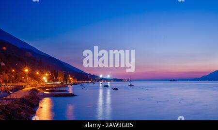 gardasee Nachtfoto malcesine, Beleuchtung vor dem Hintergrund hoher Berge Stockfoto