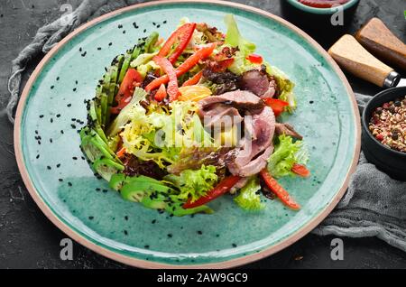 Gemüsesalat mit Avocado und Kalbfleisch. In der Platte. Draufsicht. Freier Speicherplatz für Ihren Text. Rustikaler Stil. Stockfoto