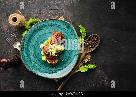 Gebackene Hähnchenhüften mit Kartoffeln. In der Platte. Draufsicht. Freier Speicherplatz für Ihren Text. Rustikaler Stil. Stockfoto