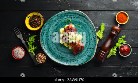 Gebackene Hähnchenhüften mit Kartoffeln. In der Platte. Draufsicht. Freier Speicherplatz für Ihren Text. Rustikaler Stil. Stockfoto