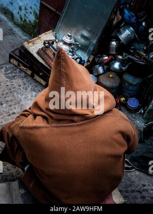 Chefchaouen, MAROKKO - CIRCA MAI 2018: Marokkanischer Mann mit einer typischen Djellaba-Sitzgruppe in der Medina in Chefchaouen Stockfoto