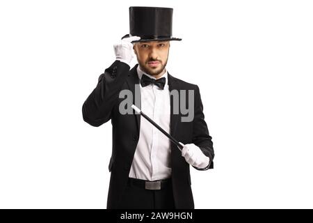 Zauberer mit einem Zauberstab, der seinen Hut hält und die Kamera auf weißem Hintergrund isoliert betrachtet Stockfoto