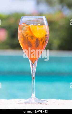 Ein Glas Aperol Spritz-Cocktail am Pool, der im tropischen Resort nass wird. Vertikal Stockfoto