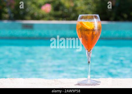 Ein Glas Aperol Spritz-Cocktail am Pool, der im tropischen Resort nass wird. Horizontal, Cocktail auf der rechten Seite Stockfoto