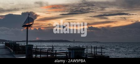 Ein Yachtsilhouette aus Metall an der Grenze von Cowes Gurnard in der Profilsilhouette gegen den Himmel bei Sonnenuntergang über dem Solent Stockfoto