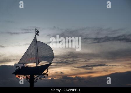 Ein Yachtsilhouette aus Metall an der Grenze von Cowes Gurnard in der Profilsilhouette gegen den Himmel bei Sonnenuntergang über dem Solent Stockfoto