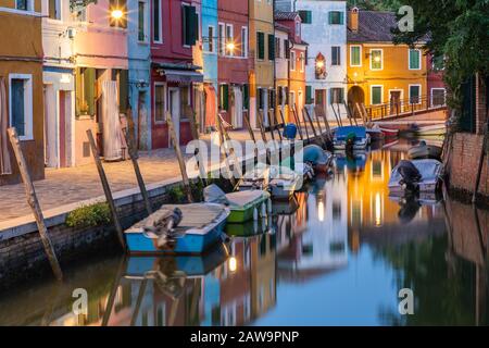 Die bunten Häuser von Burano spiegelten sich in einem der Kanäle, Burano, Venedig, Italien, wider Stockfoto