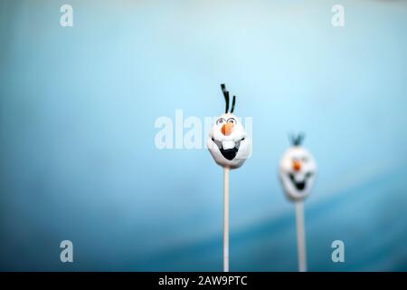 Zwei Schneekuchen knallen vor blauem Hintergrund Stockfoto