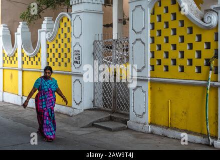 DIU, Indien - Dezember 2018: Eine Frau geht an den gelben Wänden eines Hauses auf den Straßen von Diu vorbei. Stockfoto