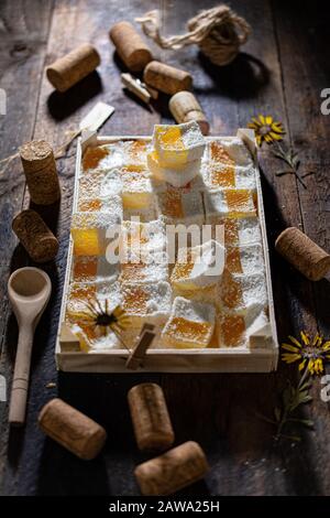 Orangefarbene Geleebohnen in einer Holzkiste. Süßes Dessert. Gesundes Essen und Obst. Stockfoto
