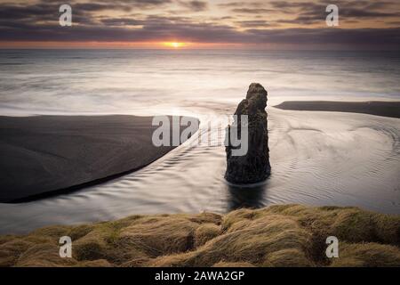 Dyrholaey Leuchtturm über schwarzem Sandstrand in Island Stockfoto