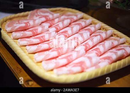 Selektiv Fokussiertes japanisches Nabemono-Kochtopf-Gericht aus dünn geschnittenem Fleisch, das in Wasser gekocht wird und mit eintauchenden Soßen serviert wird, bekannt als Shabu-Shabu. Es ist gekocht p Stockfoto