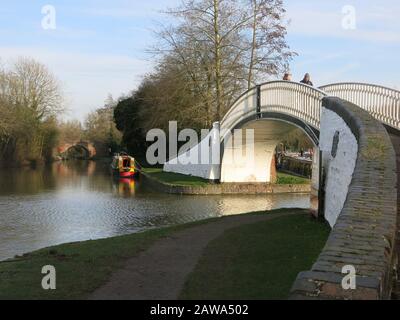 Eine der gewölbten, weißen, eisernen Fußgängerbrücken an der Einfahrt nach Braunston Marina am Canal Grande Stockfoto