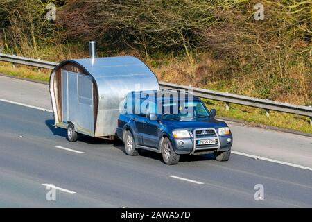 2006 Mitsubishi grauer SUV Shogun Di-D eleg-CE Lwb; unvollendeter selbstgemachter Wohnwagen wird abgeschleppt; UK Fahrzeug Verkehr, Transport, modern, Limousine Autos, Auf der Autobahn M61, Manchester, Großbritannien Stockfoto