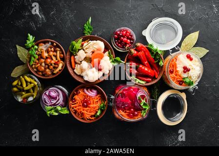 Gefülltes Gemüse und Pilze auf dem Küchentisch. Kohl, Pilze, Gurken, Blumenkohl. Draufsicht. Freier Speicherplatz für Ihren Text. Stockfoto