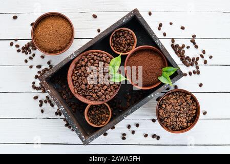 Gemahlener Kaffee und Kaffeebohnen. Auf weißem Holzhintergrund. Draufsicht. Freier Speicherplatz für Ihren Text. Stockfoto