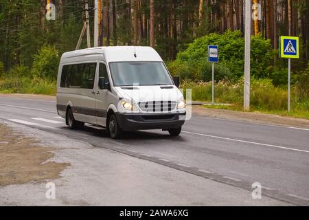 Minibus geht auf das Land Highway entlang der Wald Stockfoto