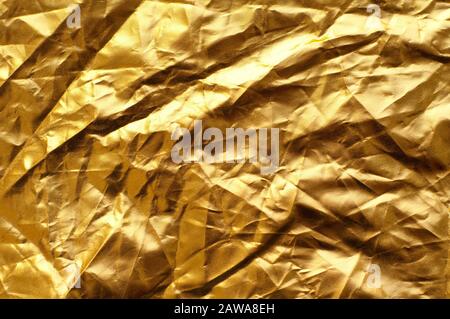 Hintergrund aus zerknautschtem Stoff in goldener Farbe. Stockfoto