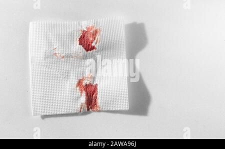 Küchenpapier Serviette im Blut. Blut mit improvisierten Mitteln stoppen. Stockfoto