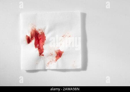 Küchenpapier Serviette im Blut. Blut mit improvisierten Mitteln stoppen. Stockfoto