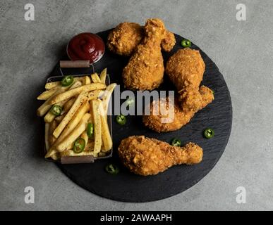 Panierte, knusprige gebratene Hühnerbeine, pommes Frites und Sauce Stockfoto