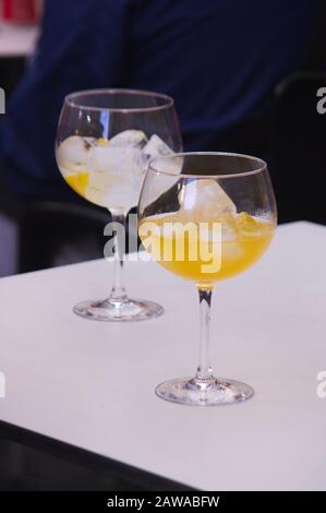 Zwei Ballongläser mit einer Art von Kombination mit viel Eis auf einem Tisch in einer Bar im Freien Stockfoto