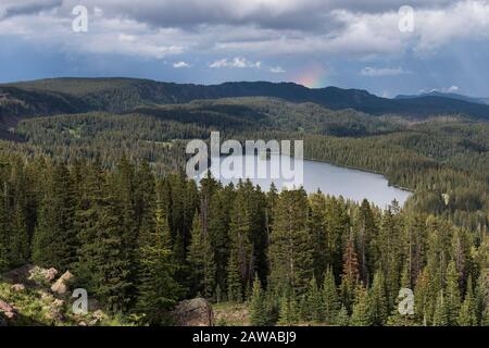 Der View Point auf dem Grand Mesa National Forest Colorado hat über 300 Seen. Teilweise Regenbogen über dem Island Lake, einer der beliebtesten Reiseziele Stockfoto