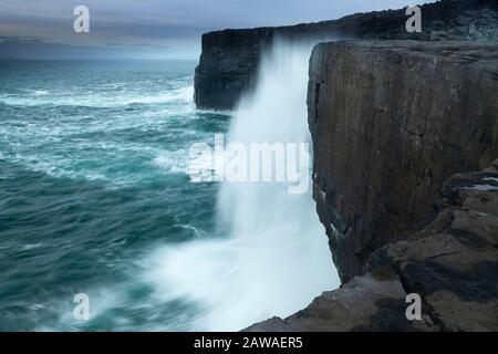 Wellen, die gegen Klippen auf der Insel Inishmaan, mitten auf den Aran-Inseln, auf dem Wilden Atlantikweg in Galway Ireland krachen Stockfoto