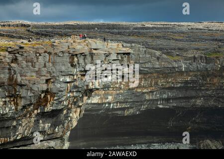 Touristen, die auf den Klippen der Insel Inishmore, der größten der Aran-Inseln auf dem Wilden Atlantikweg in Galway Ireland, stehen Stockfoto